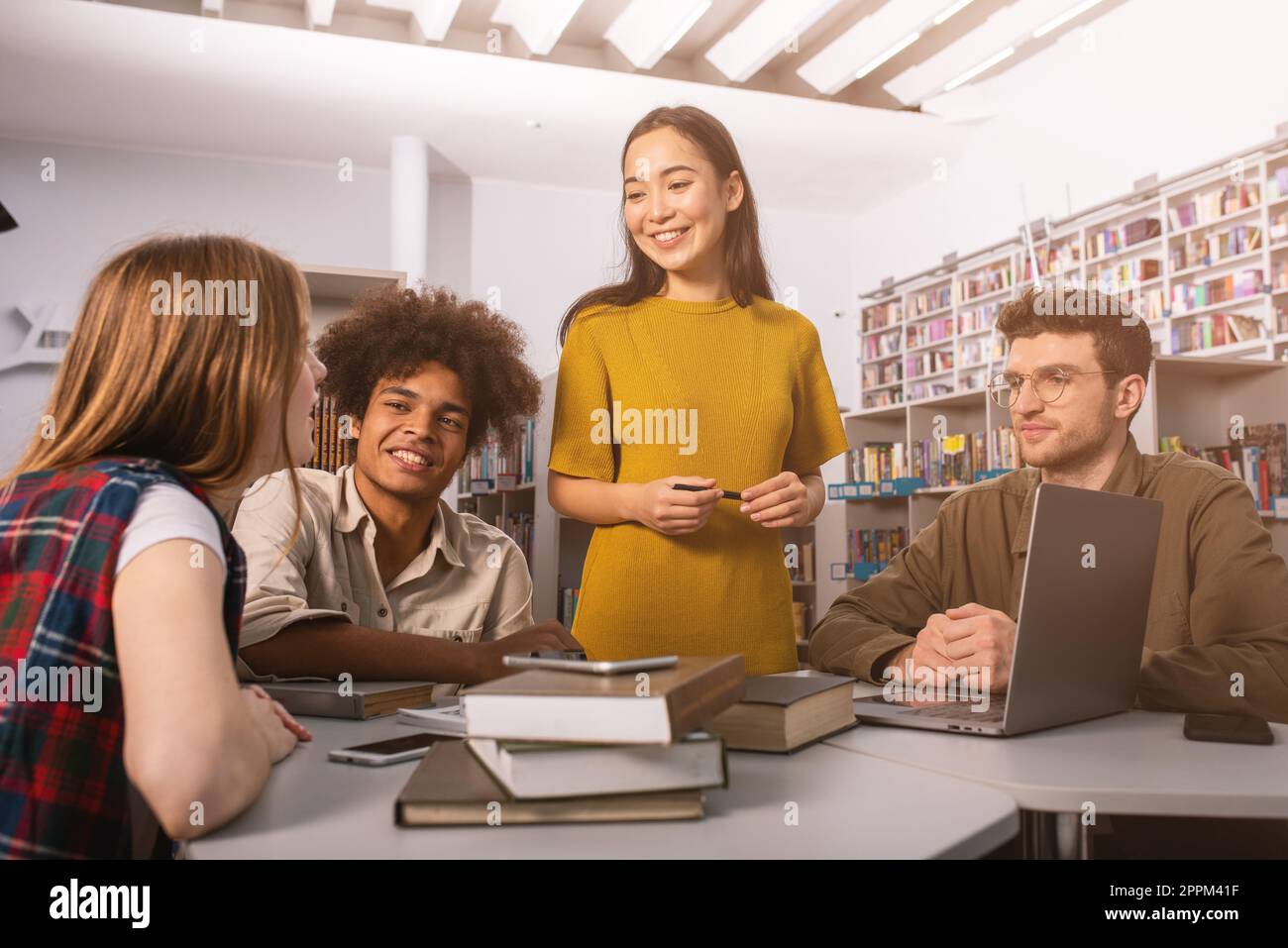 Gli studenti universitari stanno studiando in una libreria insieme. Concetto di lavoro di squadra e la preparazione Foto Stock