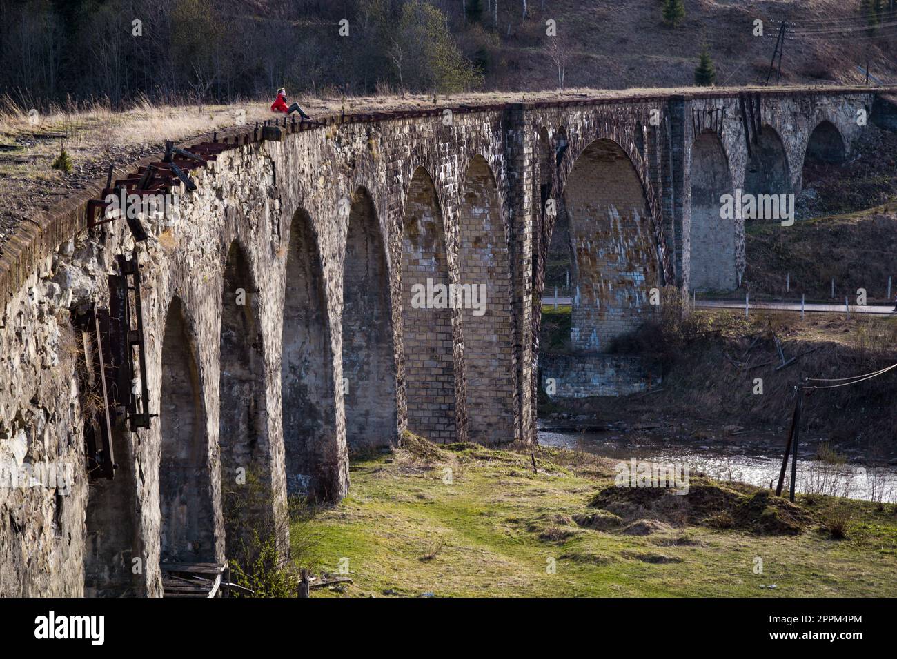 Donna seduta su un vecchio ponte di scottante foto paesaggio Foto Stock
