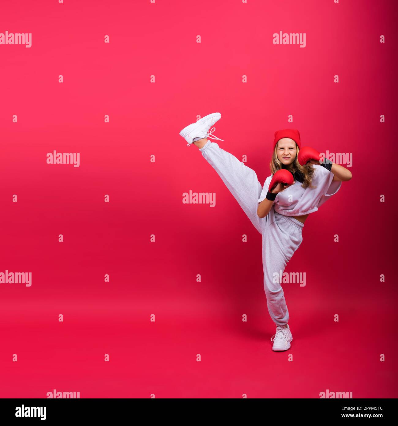 Bambina che indossa guanti da boxe rossi, scatto in studio, concetto sportivo Foto Stock