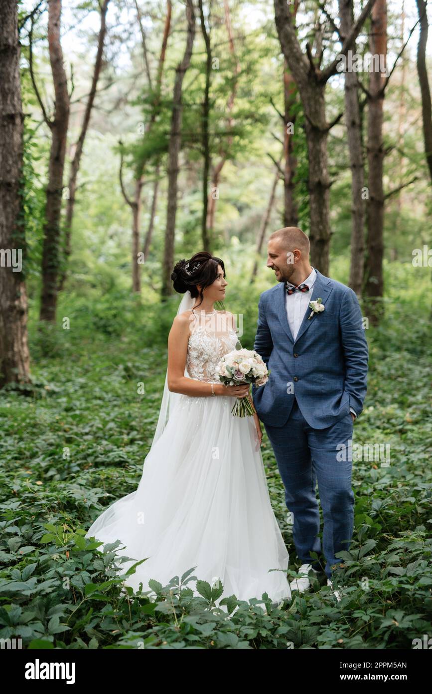 passeggiata nuziale della sposa e sposo nella foresta decidua in estate Foto Stock