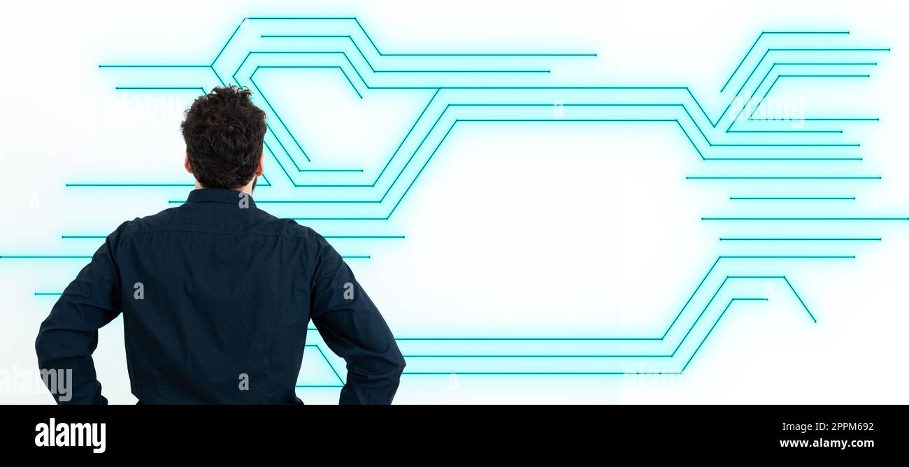 Uomo d'affari in camicia nera da ufficio con la schiena davanti a una parete bianca. Il design digitale futuristico presenta le nuove tecnologie del futuro. Bagliore colorato. Foto Stock