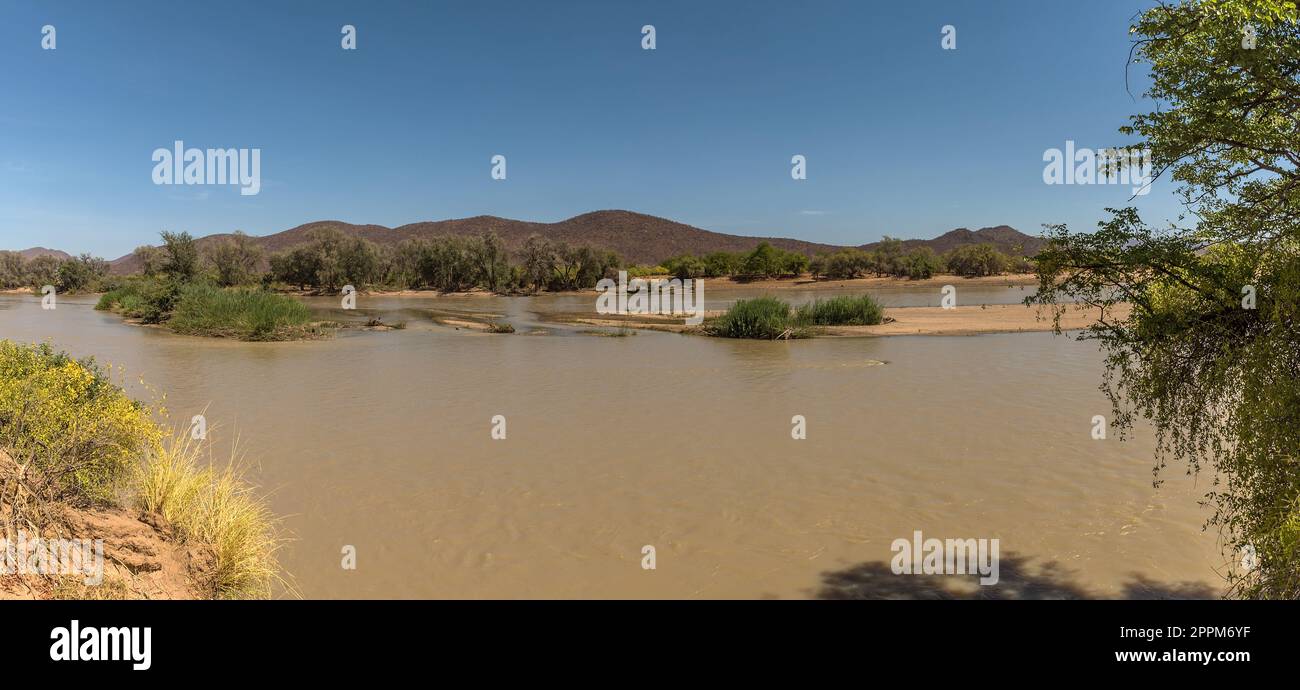 Paesaggio sulle rive del fiume Kunene, il fiume di confine tra Namibia e Angola Foto Stock