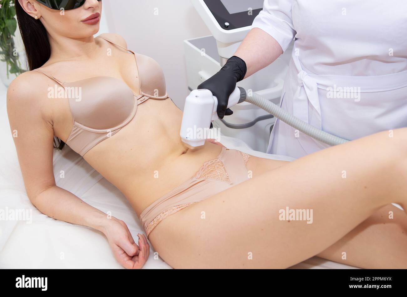 Il processo di rimozione dei peli del laser del corpo femminile, l'area addominale. Cosmetologia professionale e sicura. Concetto di cura del corpo. Foto Stock