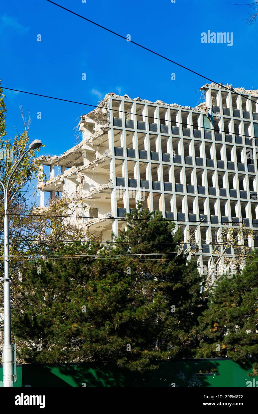 Background del processo di demolizione di edifici. Escavatore che rompono la vecchia casa. Foto Stock