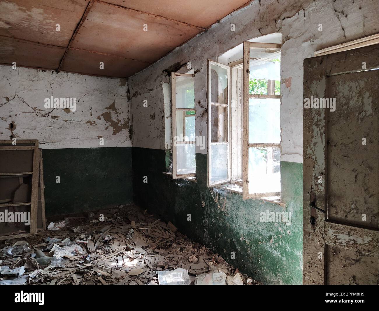 Finestre spaventose. In una casa abbandonata. Vista delle finestre rotte senza tenda. Scena grunge. La luce splende attraverso vecchie strutture in legno con vetri rotti. Il concetto di abbandono e inutilità. Foto Stock