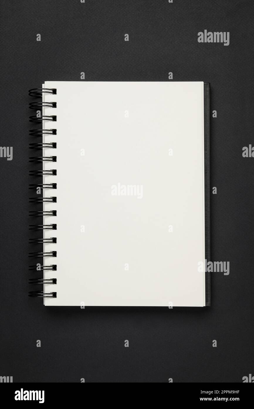 Notebook con rilegatura a spirale su sfondo nero, vista dall'alto Foto Stock
