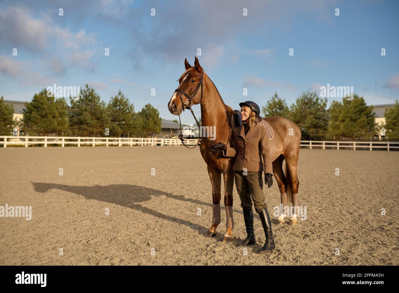 Un allenatore di cavalli con il suo stallone all'aperto in fattoria Foto Stock