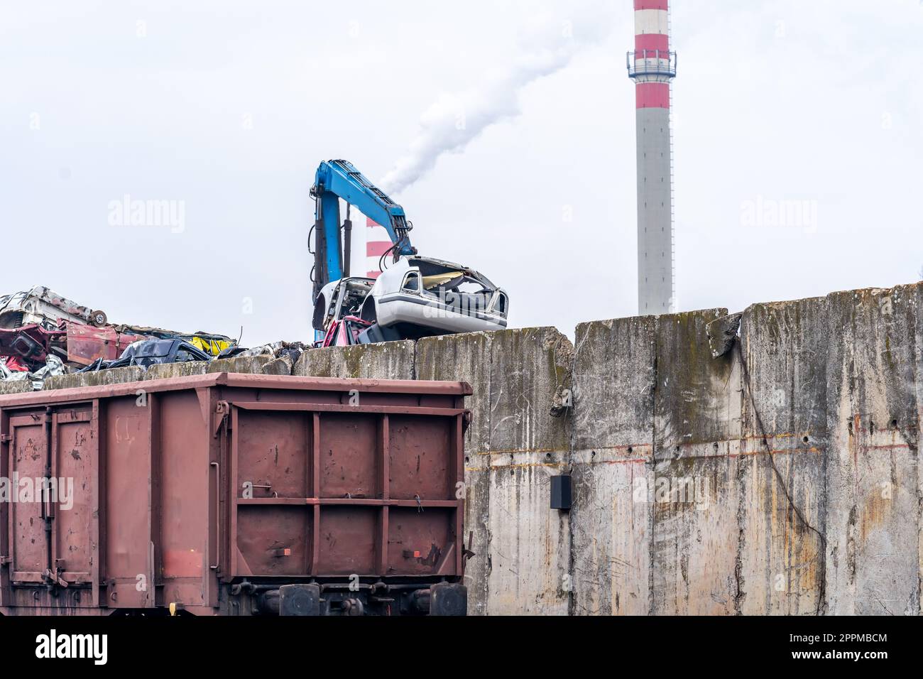 una pila di ferro caricato su un treno e un camino fumante Foto Stock
