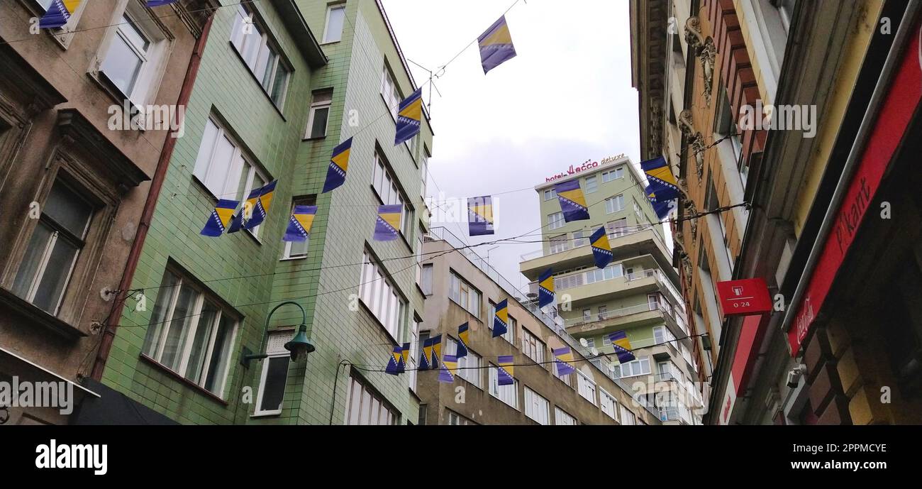 Sarajevo, Bosnia ed Erzegovina, 8 marzo 2020. Strade decorate con bandiere nazionali di Sarajevo. Antichi edifici nel centro della città. Area turistica con negozi, mostre, caffetterie e ristoranti Foto Stock