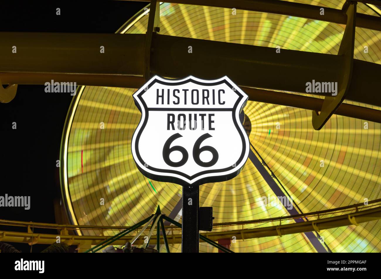 Segnaletica Route 66 e Pacific Wheel di notte Foto Stock