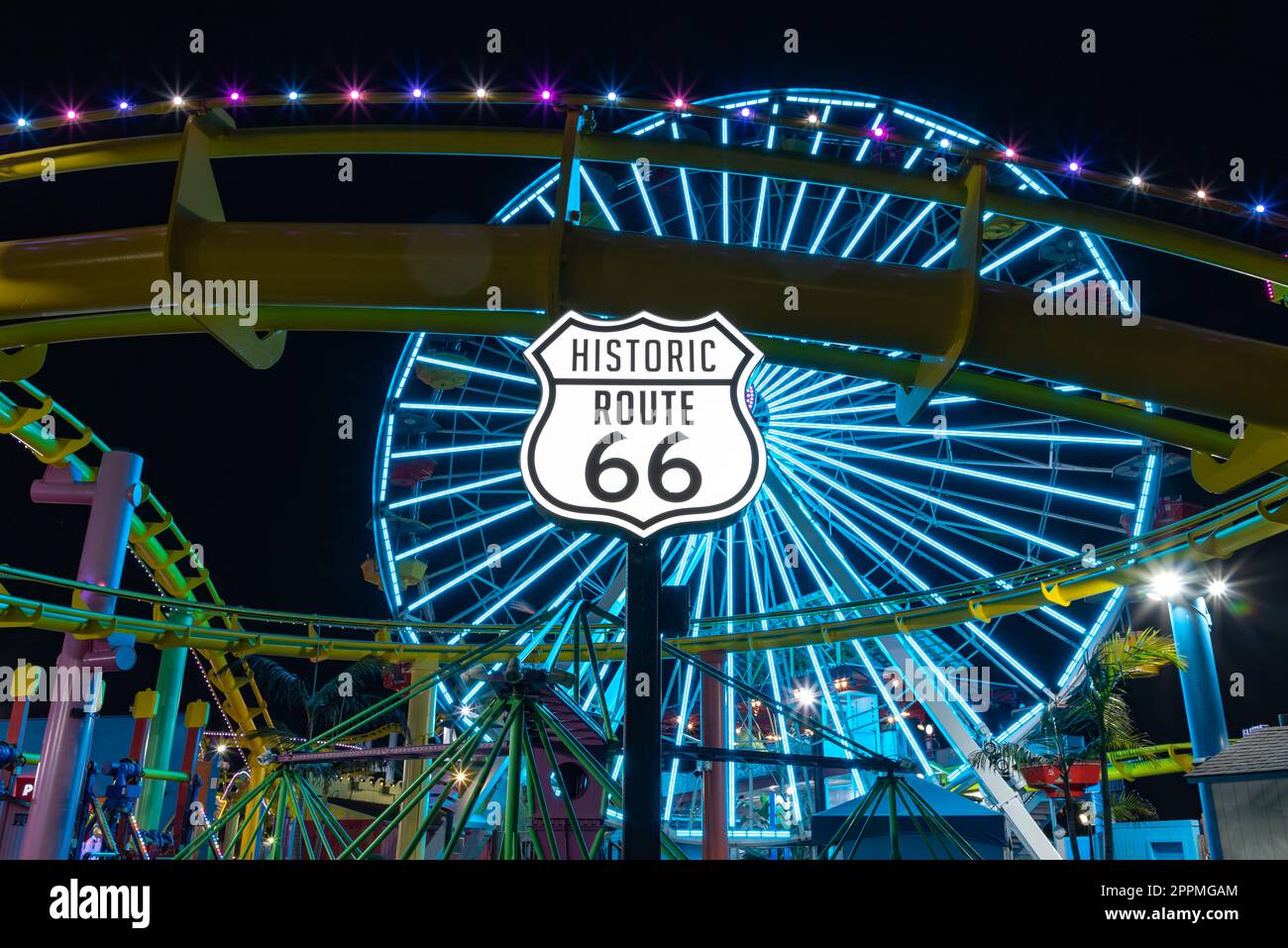 Segnaletica Route 66 e Pacific Wheel di notte Foto Stock