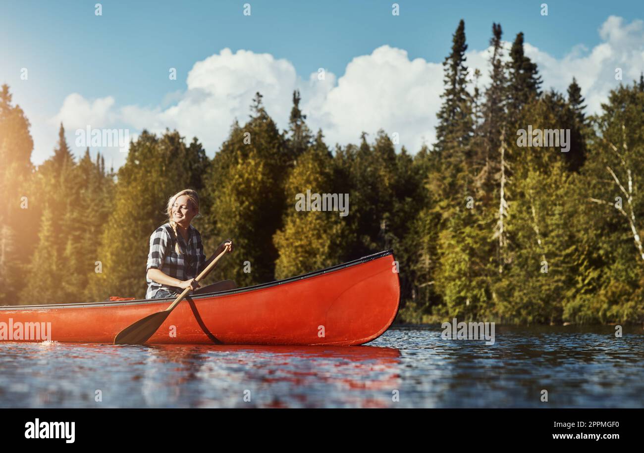 Con la H2O, il ritmo è lento. una giovane donna attraente che trascorre una giornata in kayak sul lago. Foto Stock