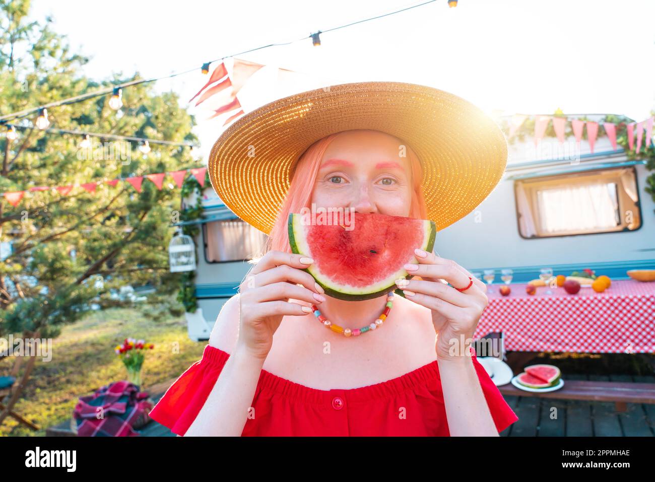 Donna mangia anguria fresca durante un picnic Foto Stock