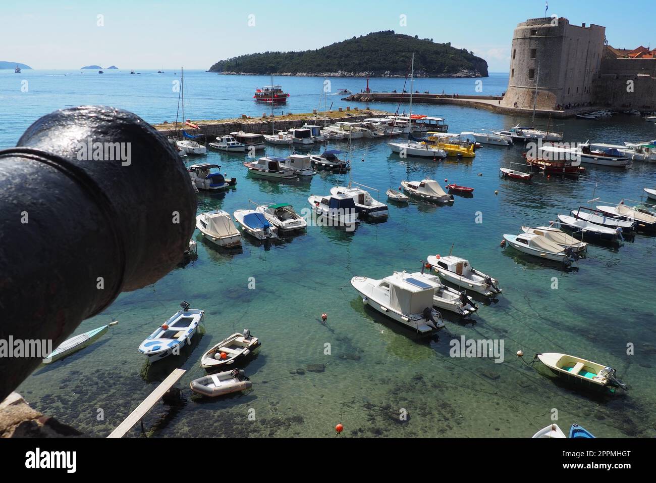 Dubrovnik, Croazia, 08.14. 2022. Attrattiva turistica estiva del porto cittadino. I turisti camminano, salgono su barche e navi e fanno gite in barca. Mare Adriatico. Viaggi. Museruola di cannoni. Barche private di cittadini locali Foto Stock