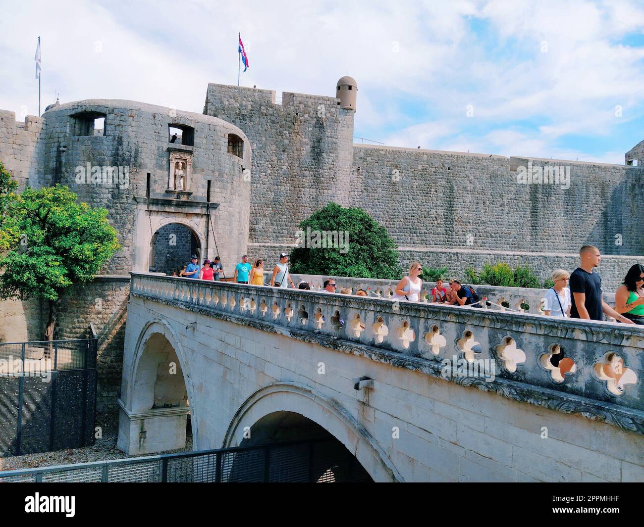 Pile Gate Dubrovnik Croazia 14 agosto 2022 persone uomini e donne camminano lungo il ponte di pietra fino alla porta della città Vecchia. Folla di turisti. Ingresso affollato. L'ingresso principale della città Vecchia, l'affollata porta pile Foto Stock