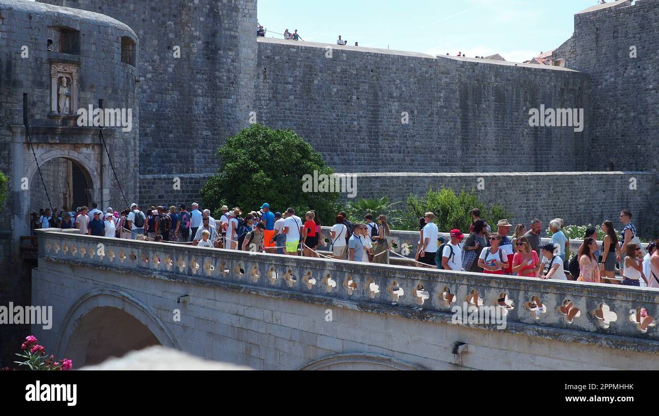 Pile Gate Dubrovnik Croazia 14 agosto 2022 persone uomini e donne camminano lungo il ponte di pietra fino alla porta della città Vecchia. Folla di turisti. Ingresso affollato. L'ingresso principale della città Vecchia, l'affollata porta pile Foto Stock