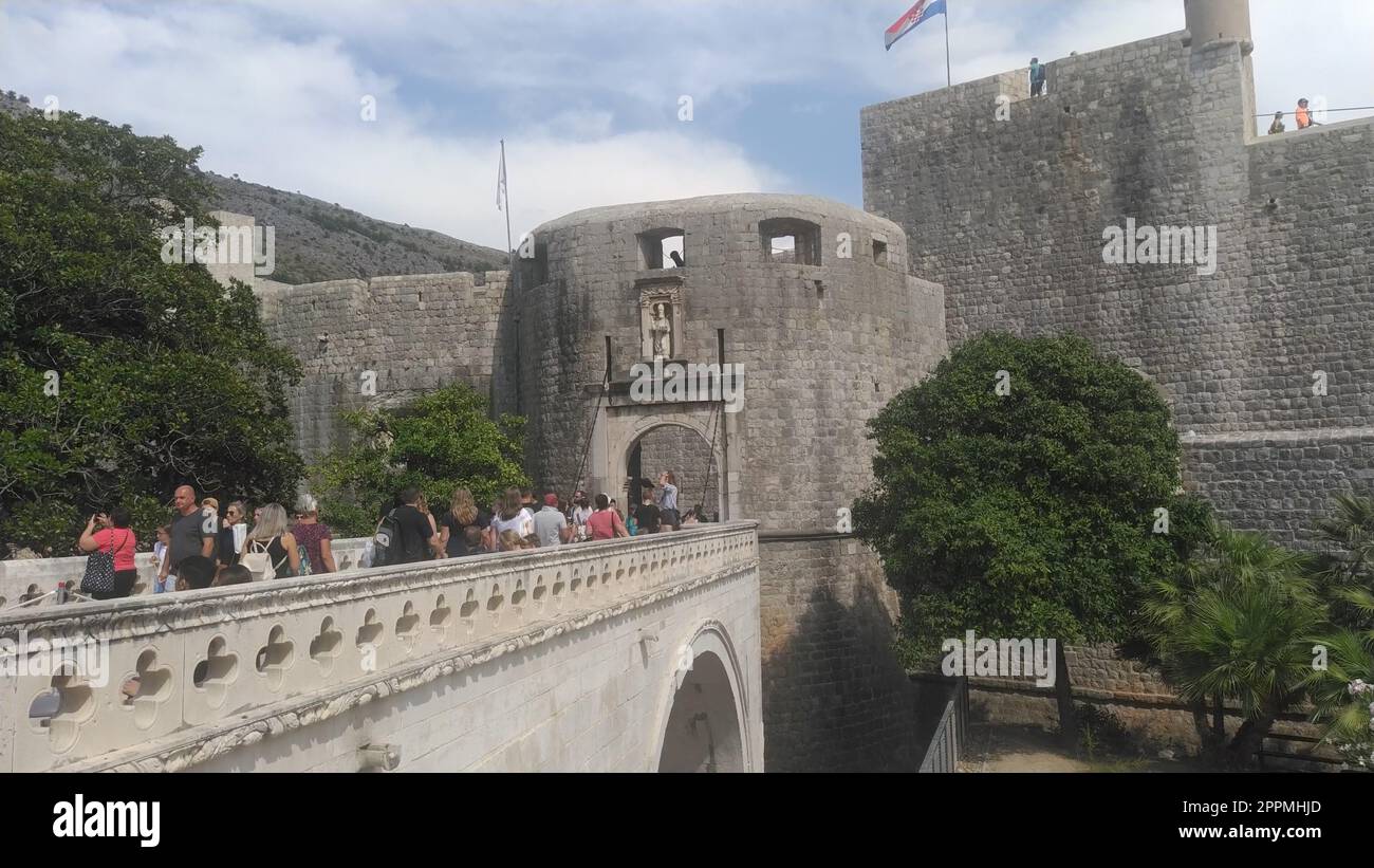 Pile Gate Dubrovnik Croazia 14 agosto 2022 persone uomini e donne camminano lungo il ponte di pietra fino alla porta della città Vecchia. Folla di turisti. Ingresso affollato. L'ingresso principale della città Vecchia, l'affollata porta pile Foto Stock