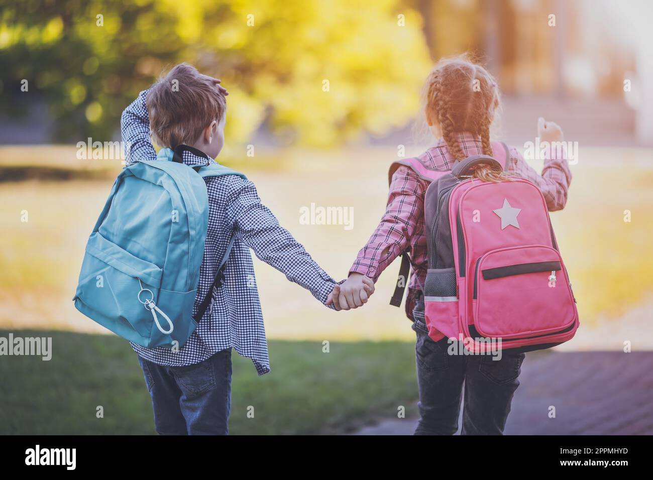 Ragazza e ragazzo che vanno a scuola tenendo le mani per studiare ad esso. Foto Stock