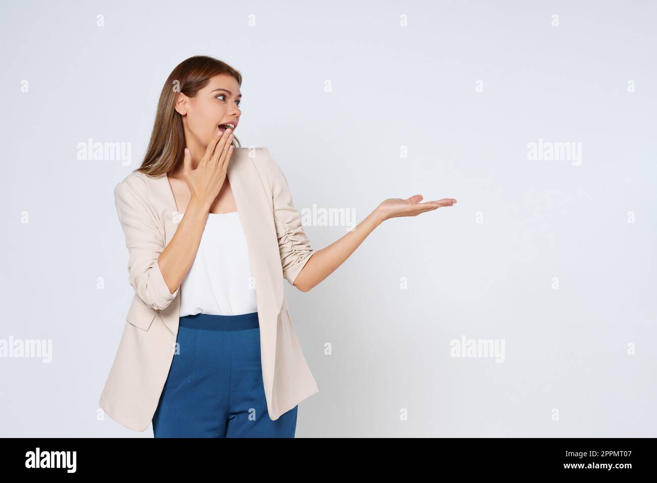 Felice giovane donna che presenta o mostra mano aperta palmo con spazio copia per il prodotto isolato su sfondo bianco. Foto Stock
