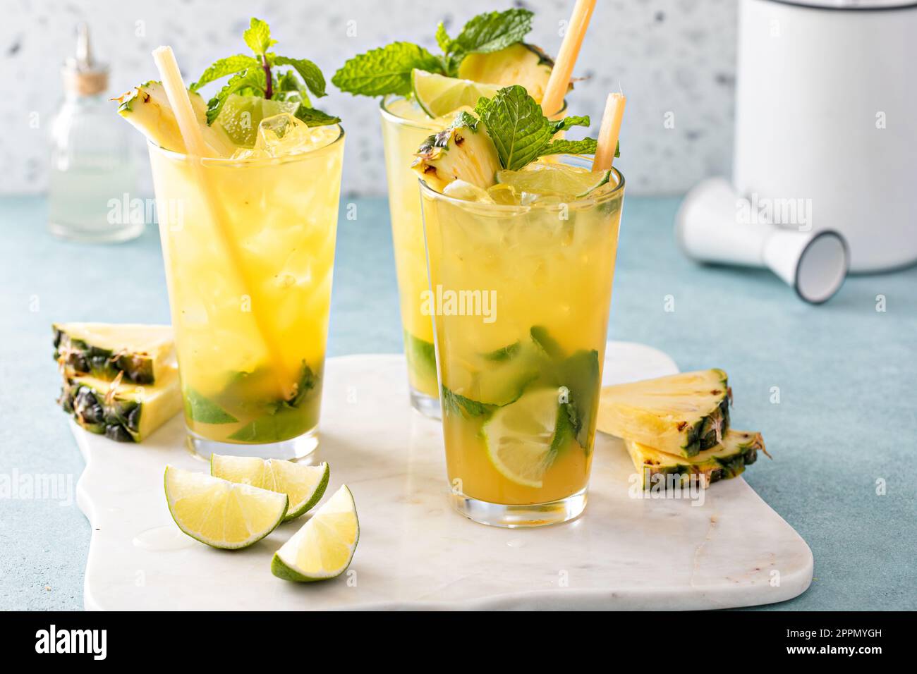 Ananas mojito con lime e menta e una fetta di ananas guarnita con bastone di canna da zucchero Foto Stock
