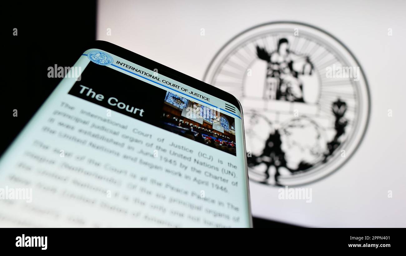 Telefono cellulare con pagina web della Corte Internazionale di Giustizia (ICJ) sullo schermo di fronte al logo. Messa a fuoco in alto a sinistra del display del telefono. Foto Stock