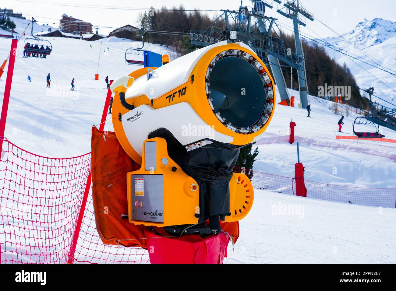 Les Ménuires, Francia - 16 marzo 2023 : il costruttore di neve gialla utilizzava la neve artificiale nella stazione sciistica di Les Ménuires nelle Alpi francesi - pistola da neve con un Foto Stock