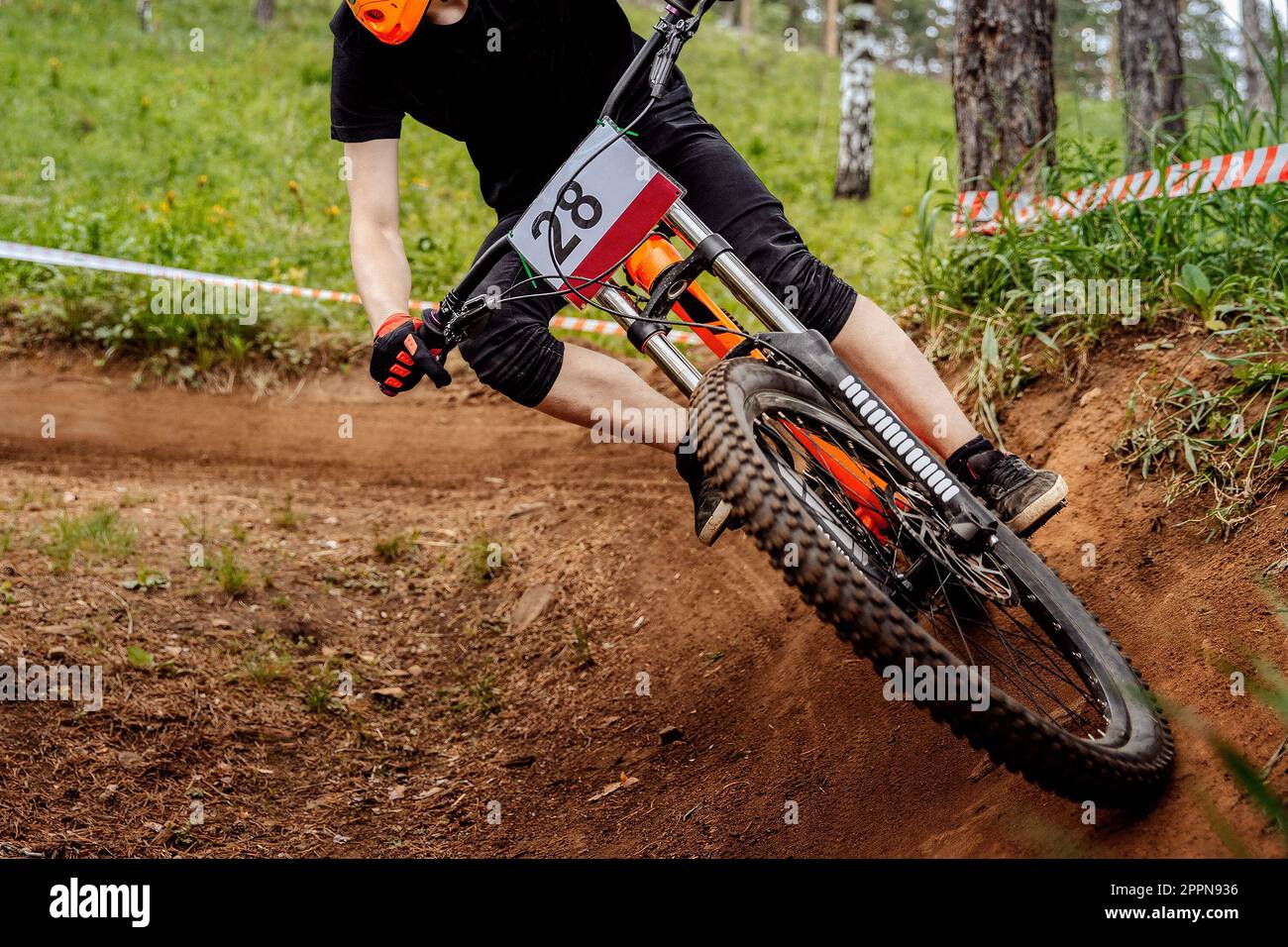 atleta da corsa maschile in curva svolta in discesa, primo piano in mountain bike con ruota anteriore Foto Stock