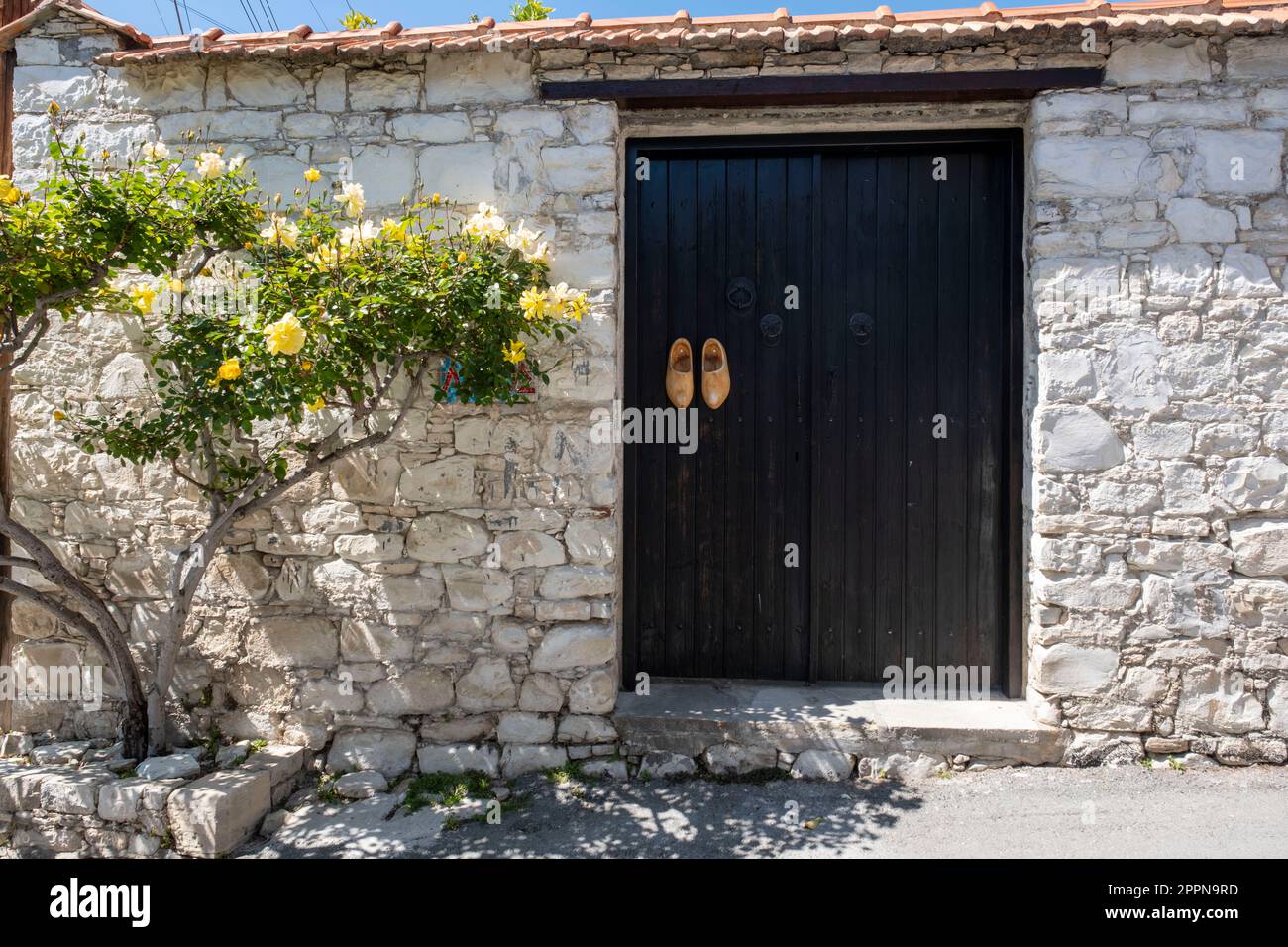Zoccoli di legno decorano le porte d'ingresso di una proprietà nel villaggio cipriota di Lania, quartiere di Limassol, Cipro. Foto Stock