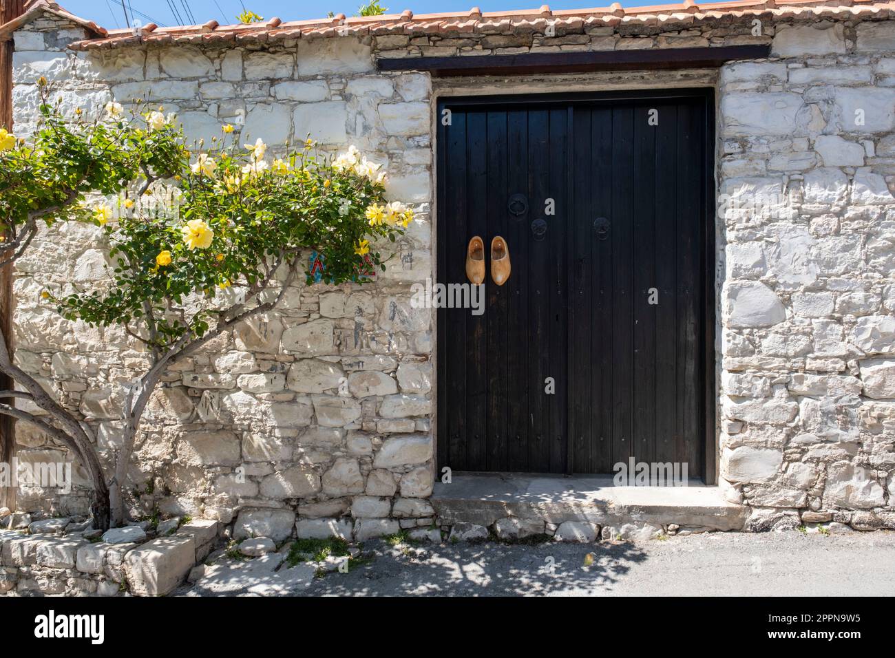 Zoccoli di legno decorano le porte d'ingresso di una proprietà nel villaggio cipriota di Lania, quartiere di Limassol, Cipro. Foto Stock