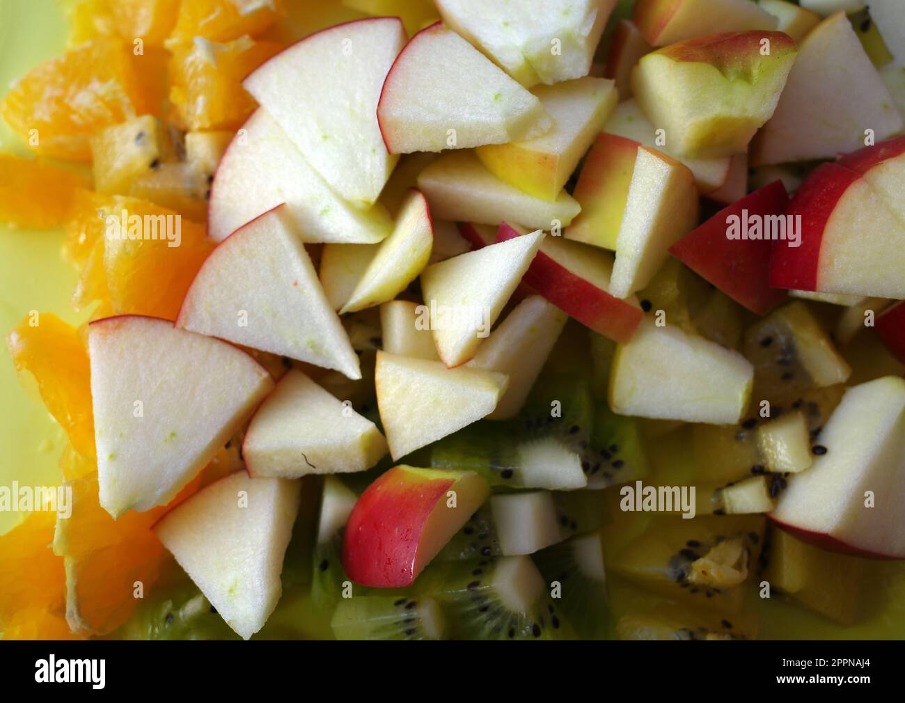 Pezzi di frutta fresca tagliata. Mela, kiwi arancione e verde Foto Stock