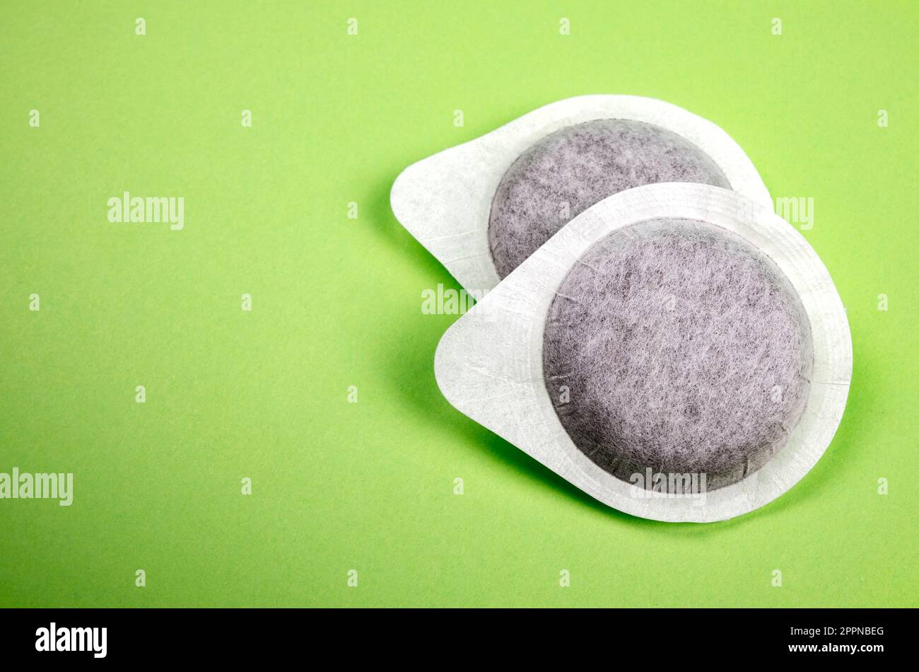 Cialde di caffè su sfondo verde Foto Stock