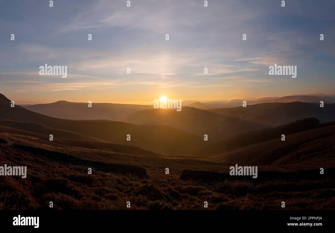 Tramonto che guarda fuori dalle colline del Peak District, nel Dark Peak da Derwent Edge, il caldo bagliore del sole tramontato su questo paesaggio inglese Foto Stock