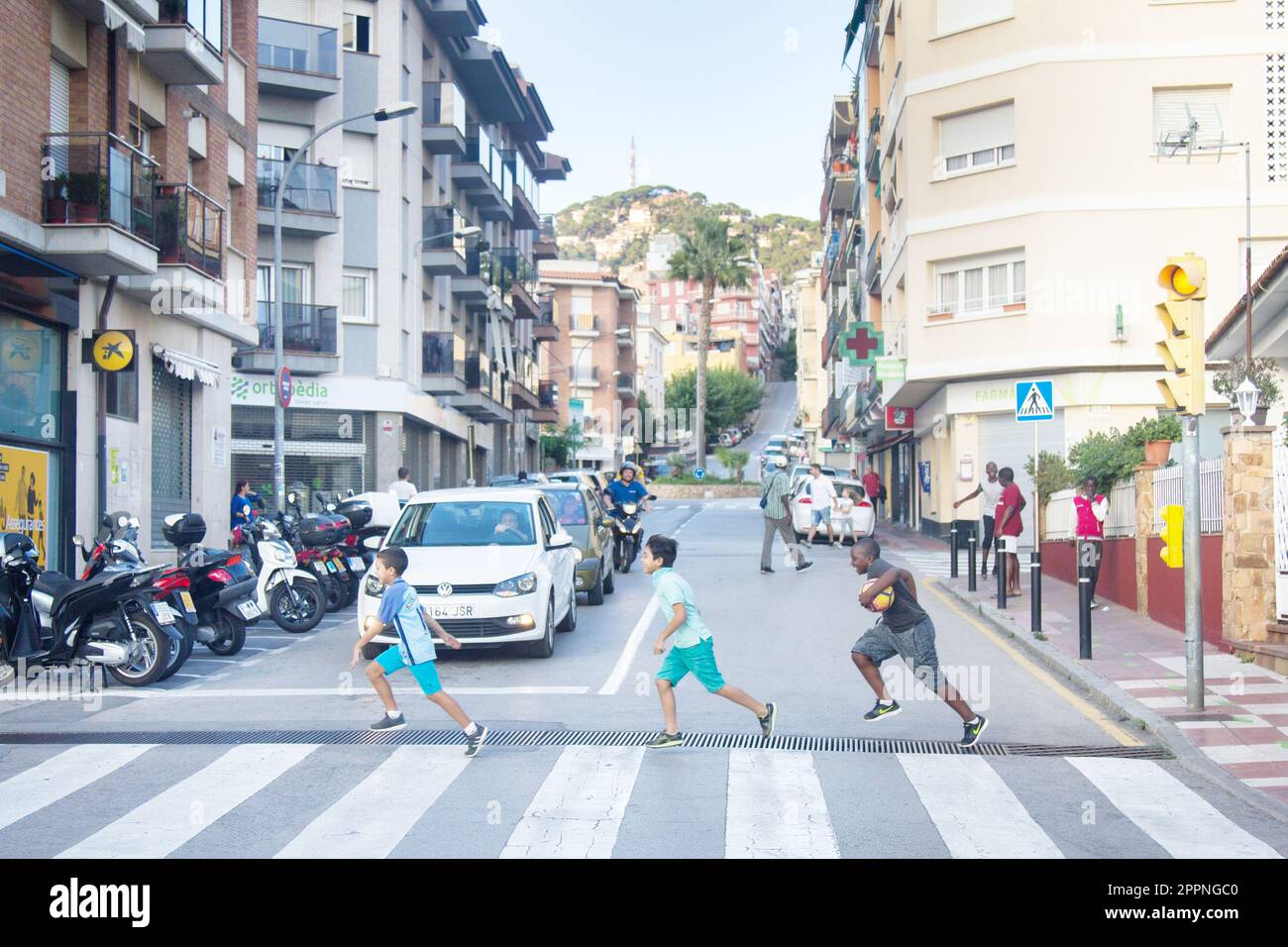 Spagna, Leora de Mar - 3 ottobre 2017: Una delle strade. I bambini di diverse gare corrono dall'altra parte della strada al semaforo verde, internazionale Foto Stock