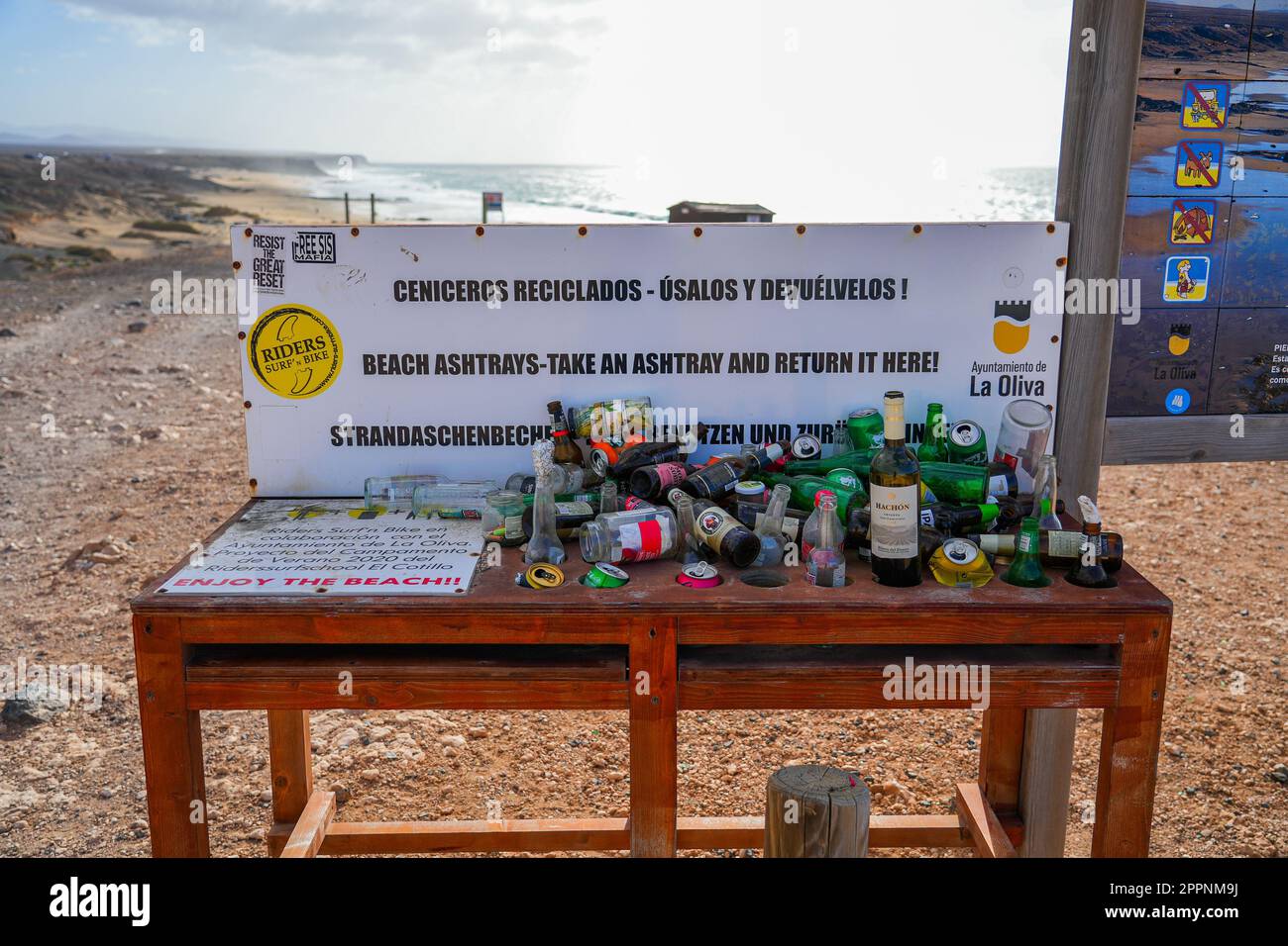 Tavolo installato sulla Playa del Castillo ("Spiaggia del Castello") per la distribuzione di posacenere e coperto di rifiuti nel nord di Fuerteventura in Th Foto Stock