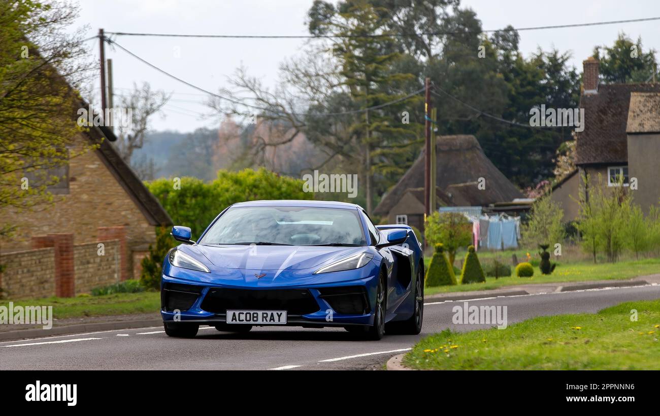 Bicester,Oxon,UK - Apr 23rd 2023. Blue 2022 CHEVROLET CORVETTE STINGRAY guida attraverso un villaggio inglese in 'Drive IT Day' un evento progettato per rai Foto Stock