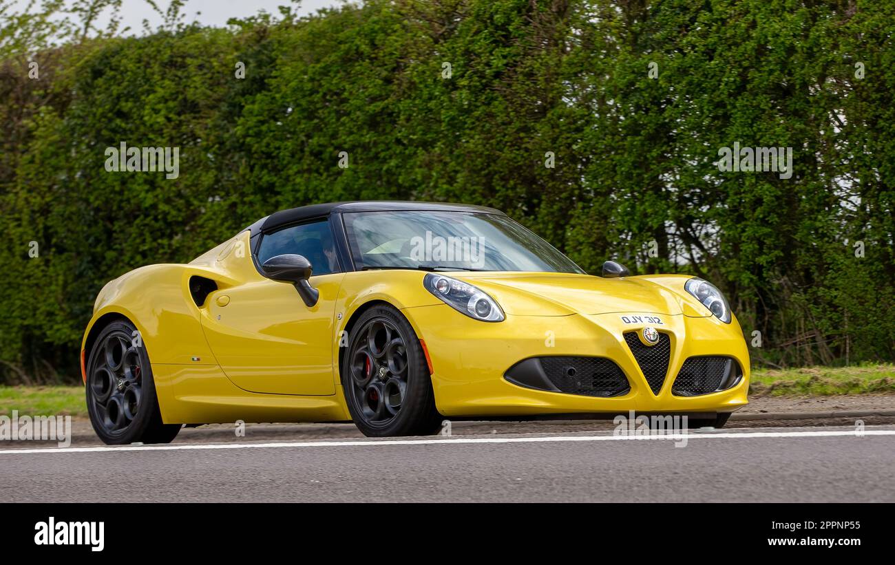 Bicester, Oxon, Regno Unito - Aprile 23rd 2023. 2015 giallo Alfa Romeo 4C auto in viaggio su una strada di campagna inglese Foto Stock