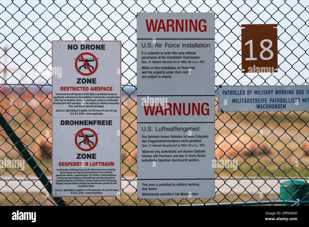 Cartelli di avvertimento bilingue "no drone zone" per lo spazio aereo limitato sulla recinzione della base aerea militare degli Stati Uniti a Ramstein, Germania Foto Stock