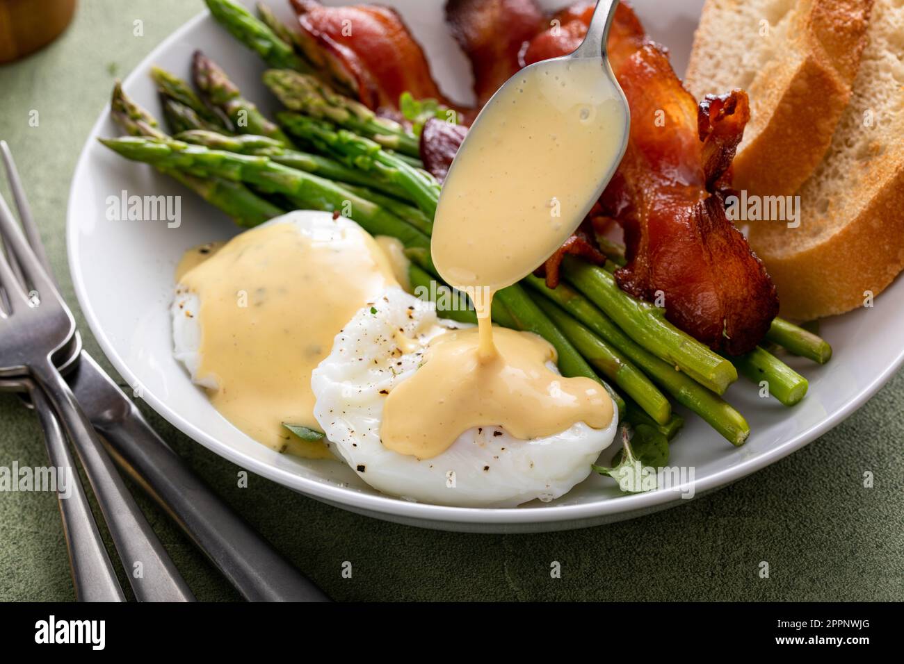 Colazione sana con uova in camicia, pancetta e asparagi serviti con salsa di hollandaise Foto Stock