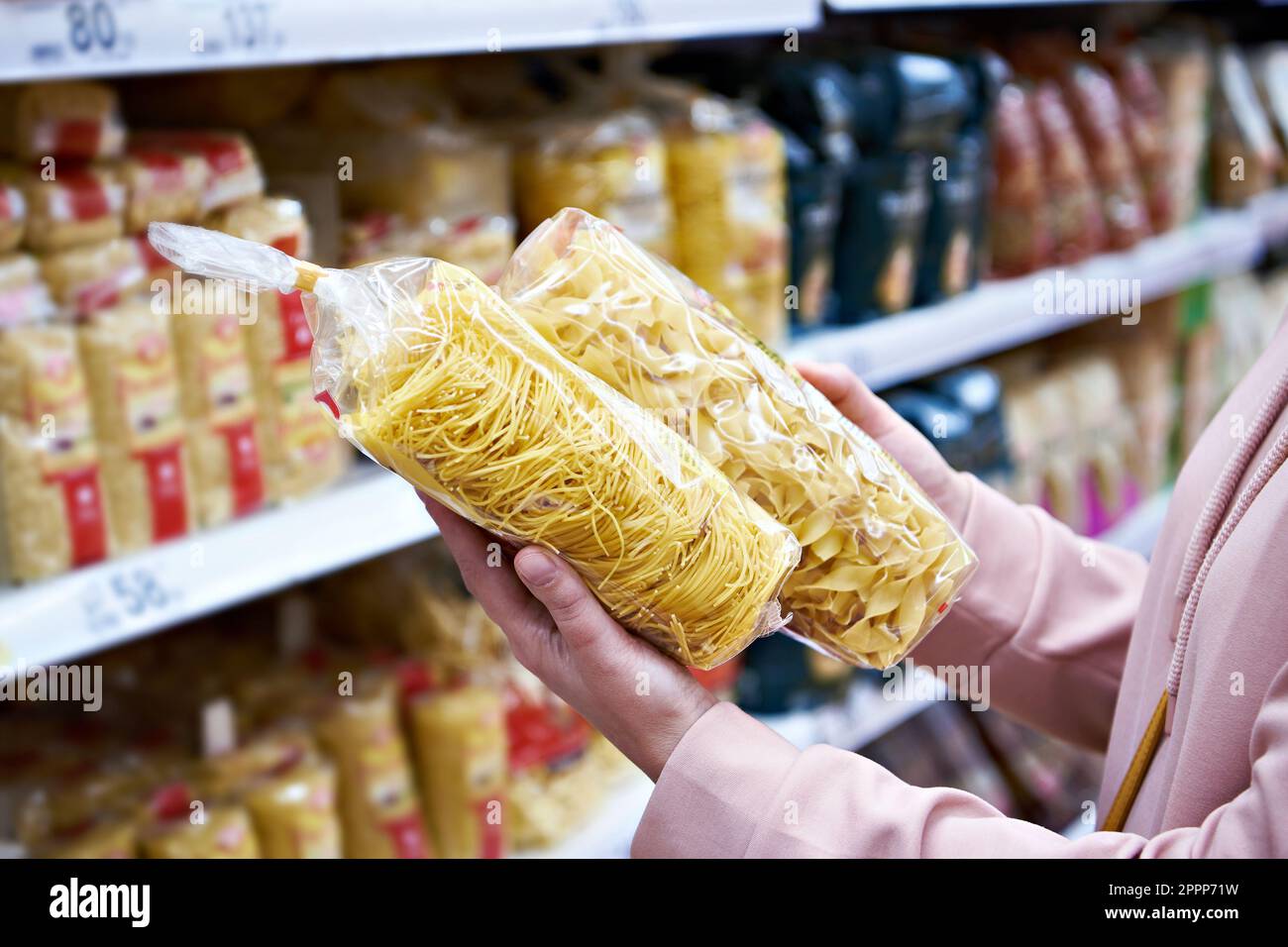Donna acquirente con una confezione di pasta a shop Foto Stock