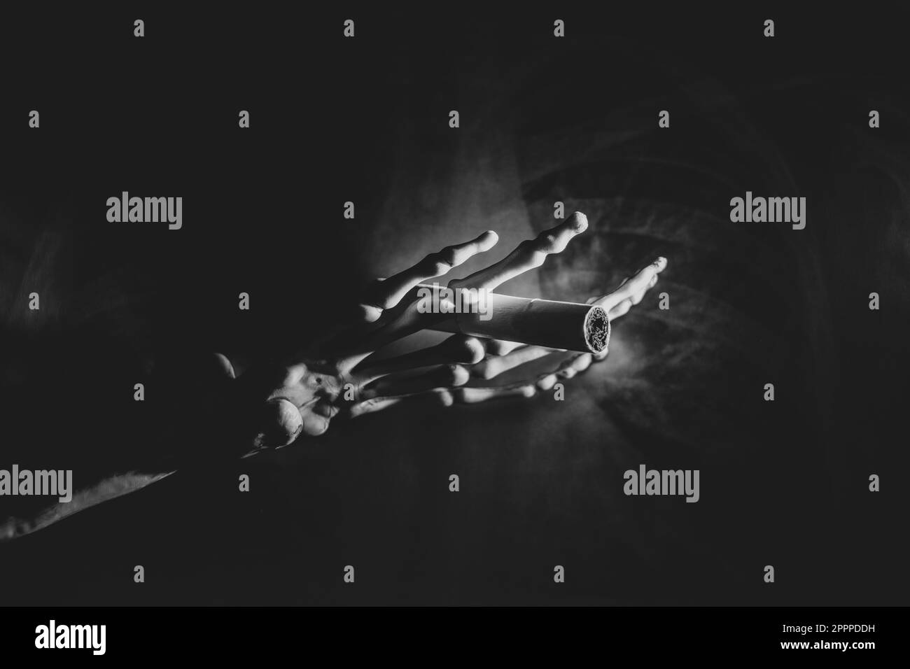 Mano scheletrica con una sigaretta su una foto radiografica dei polmoni al buio, fumo e danni alla salute, foto in bianco e nero Foto Stock