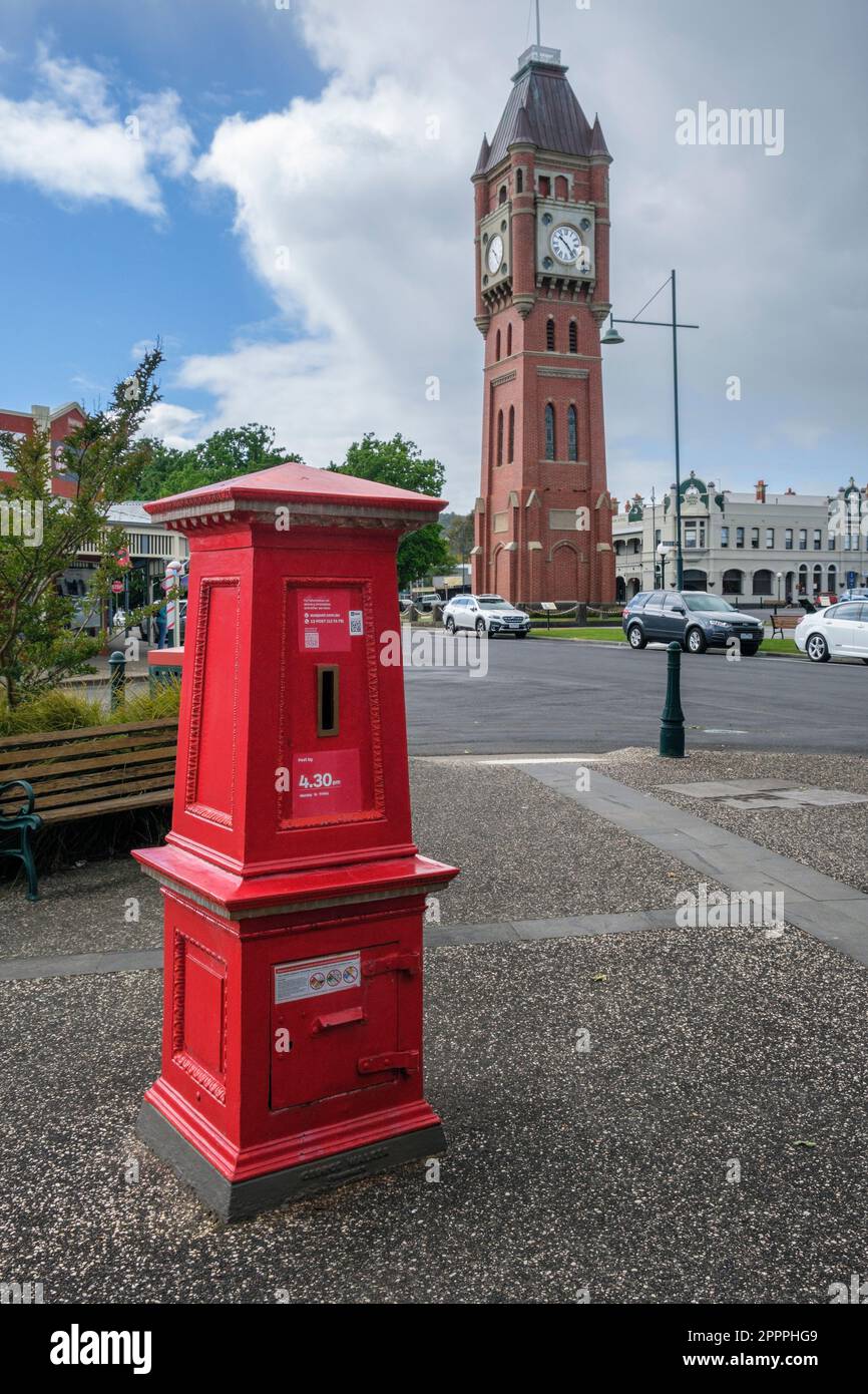Una cassetta postale vintage a Camperdown con la famosa torre dell'orologio sullo sfondo, Victoria, Australia Foto Stock