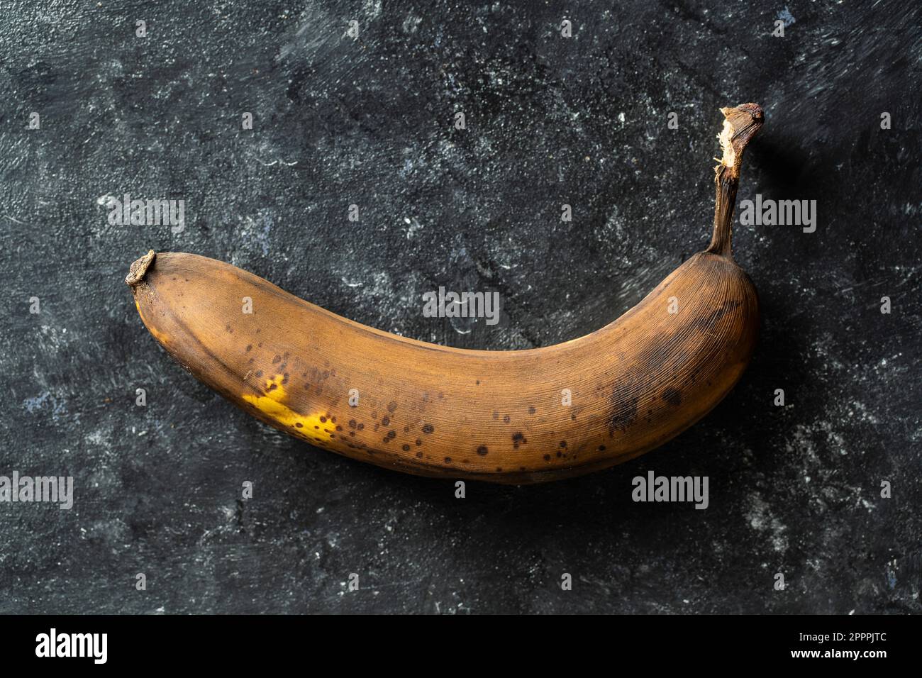 Banana marrone overmature su sfondo nero. Primo piano, vista dall'alto Foto Stock