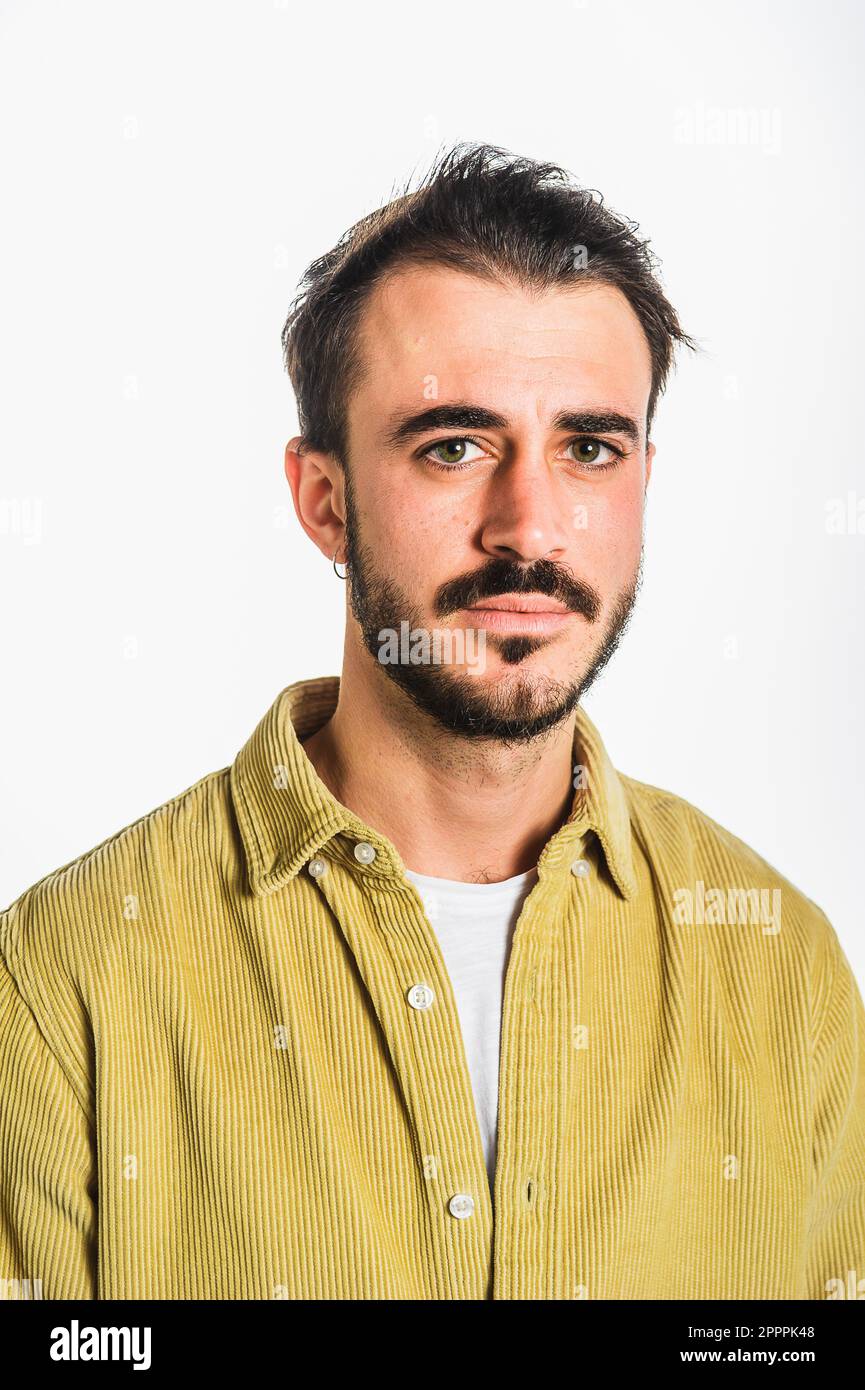 Classico ritratto frontale di un uomo caucasico con barba e baffi, marrone scuro con occhi blu, con camicia beige fustagno. Isolato contro il bianco Foto Stock