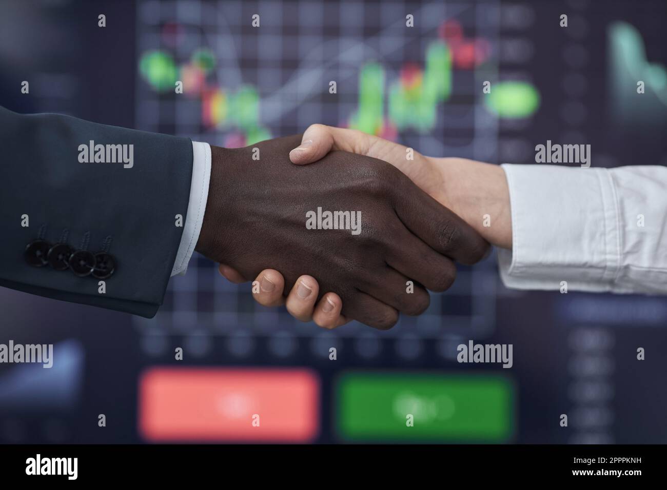 Primo piano dei mediatori che scuotono le mani per concludere un contratto durante il commercio delle azioni nell'ufficio di mediazione Foto Stock