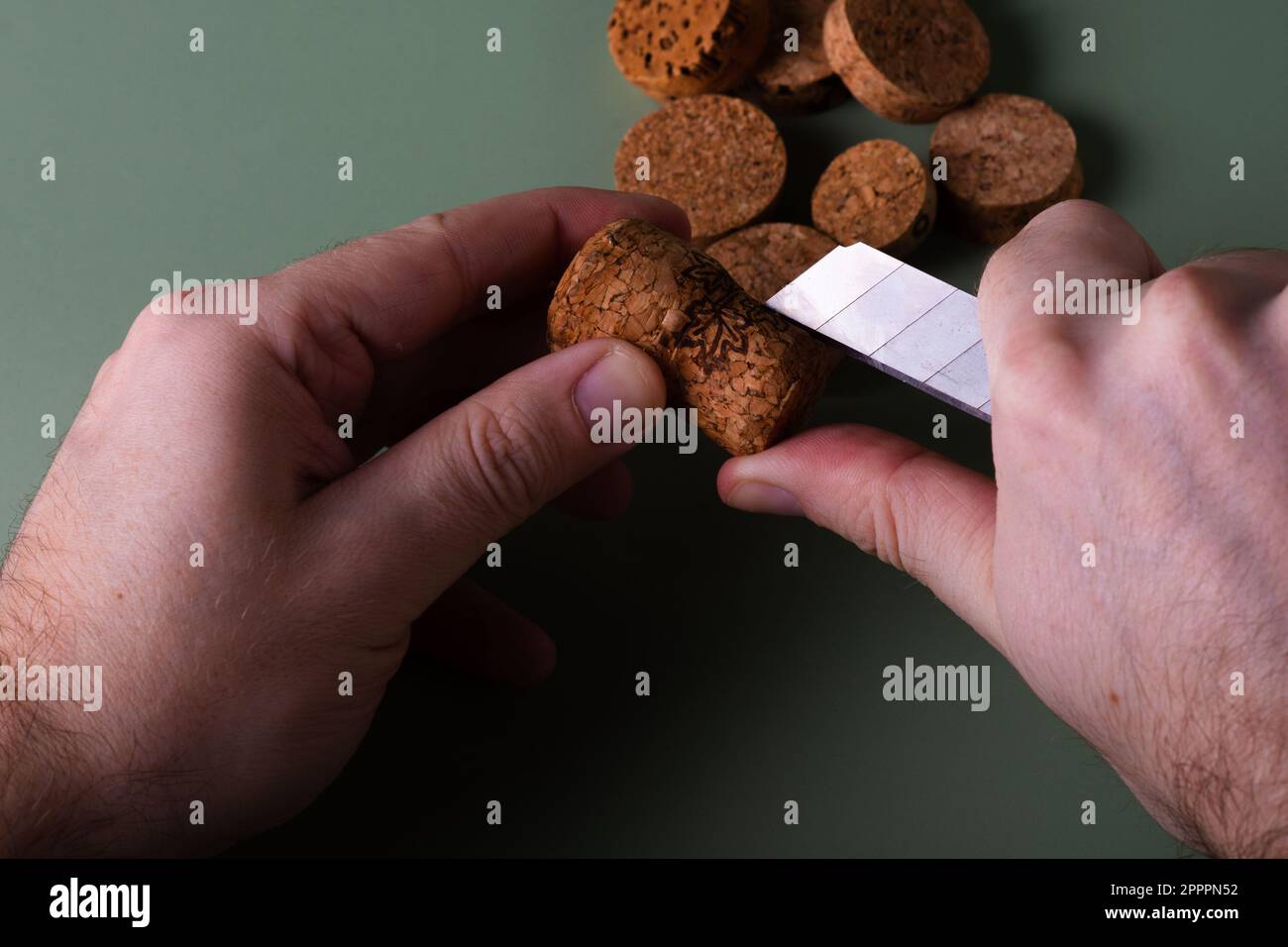 La mano di un uomo tiene i tappi tagliati e li taglia. Preservazione dell'ecologia del pianeta. Materie prime per il riutilizzo. Protezione ambientale. Foto Stock