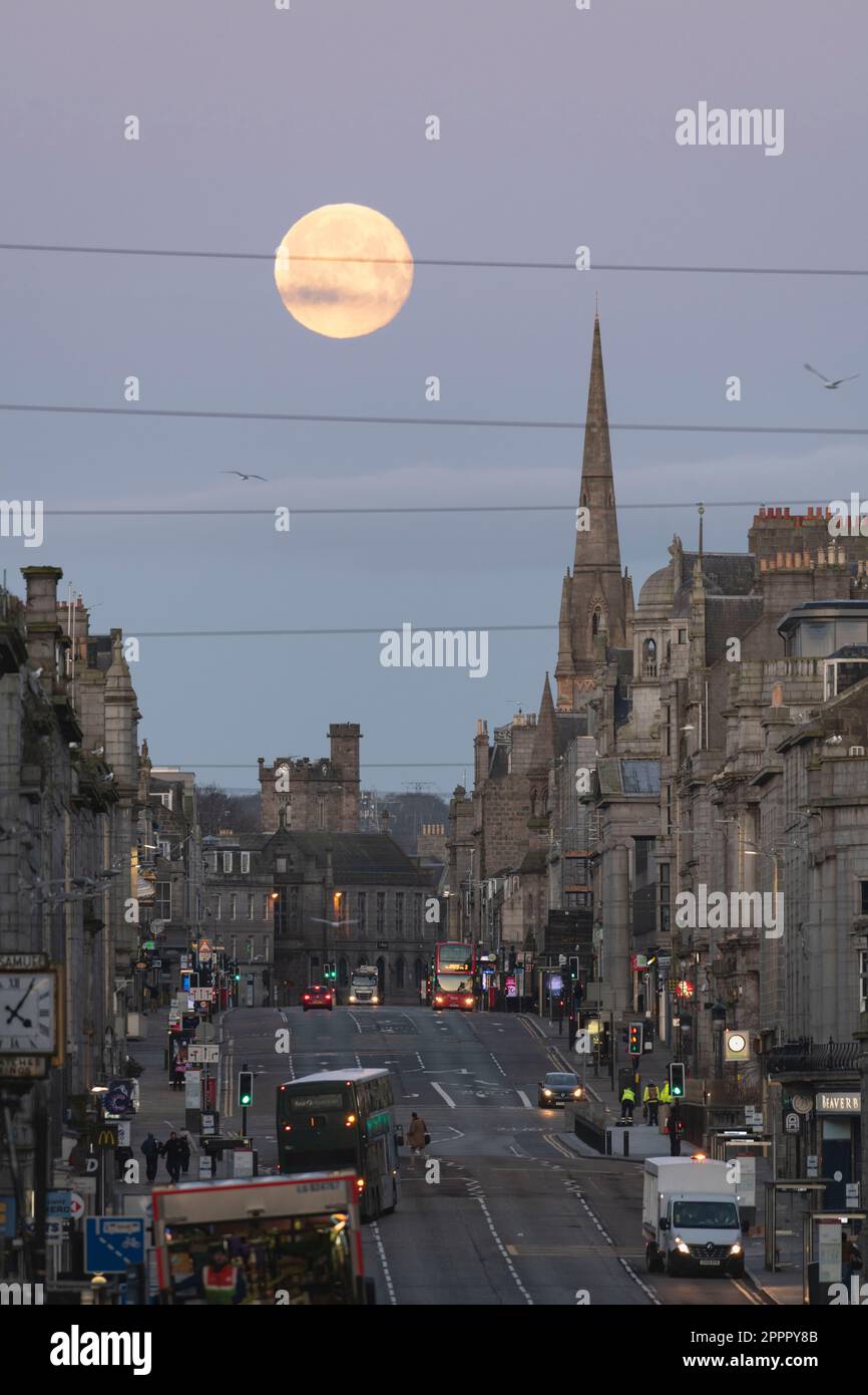 Una veduta lungo Union Street, la strada principale nel centro di Aberdeen, prima dell'alba con l'ambientazione della Luna piena al West End all'inizio di aprile Foto Stock