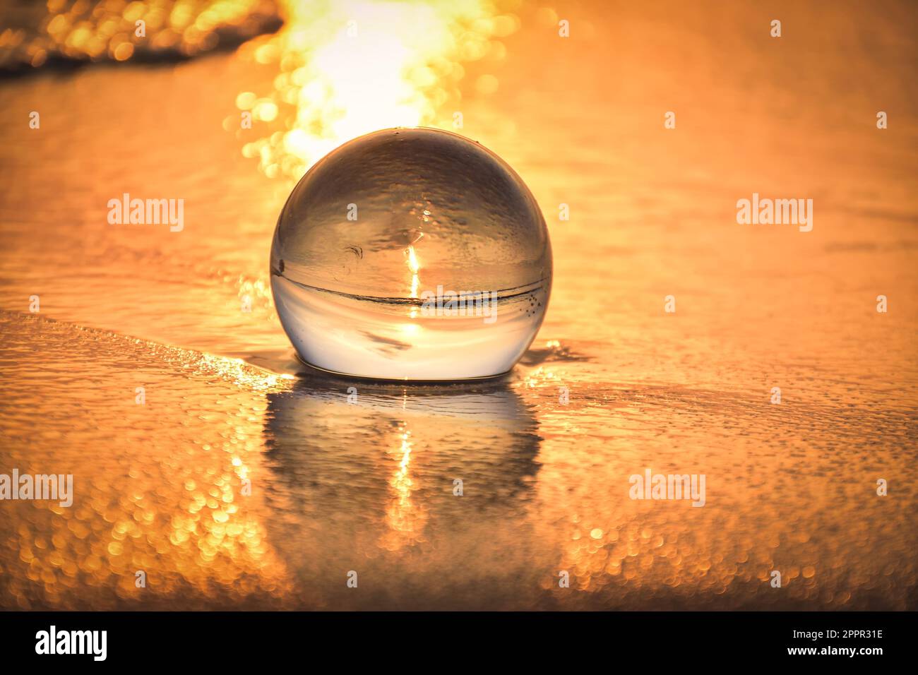 Idea astratta con acqua con un effetto interessante. Palla di vetro su sfondo sfocato su una spiaggia di Jastarnia, Polonia. Foto con un poco profondo Foto Stock