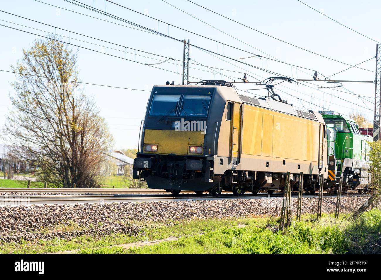 Potente locomotiva elettrica che tira un treno merci in un giorno di primavera suny Foto Stock