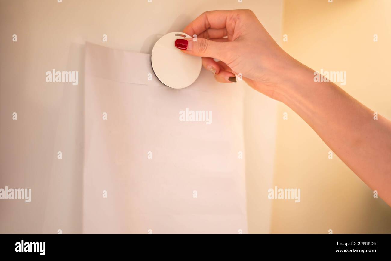 Mano femmina che fissa pezzi di carta bianca alla scheda magnetica per ricordare l'avviso importante. Foto Stock