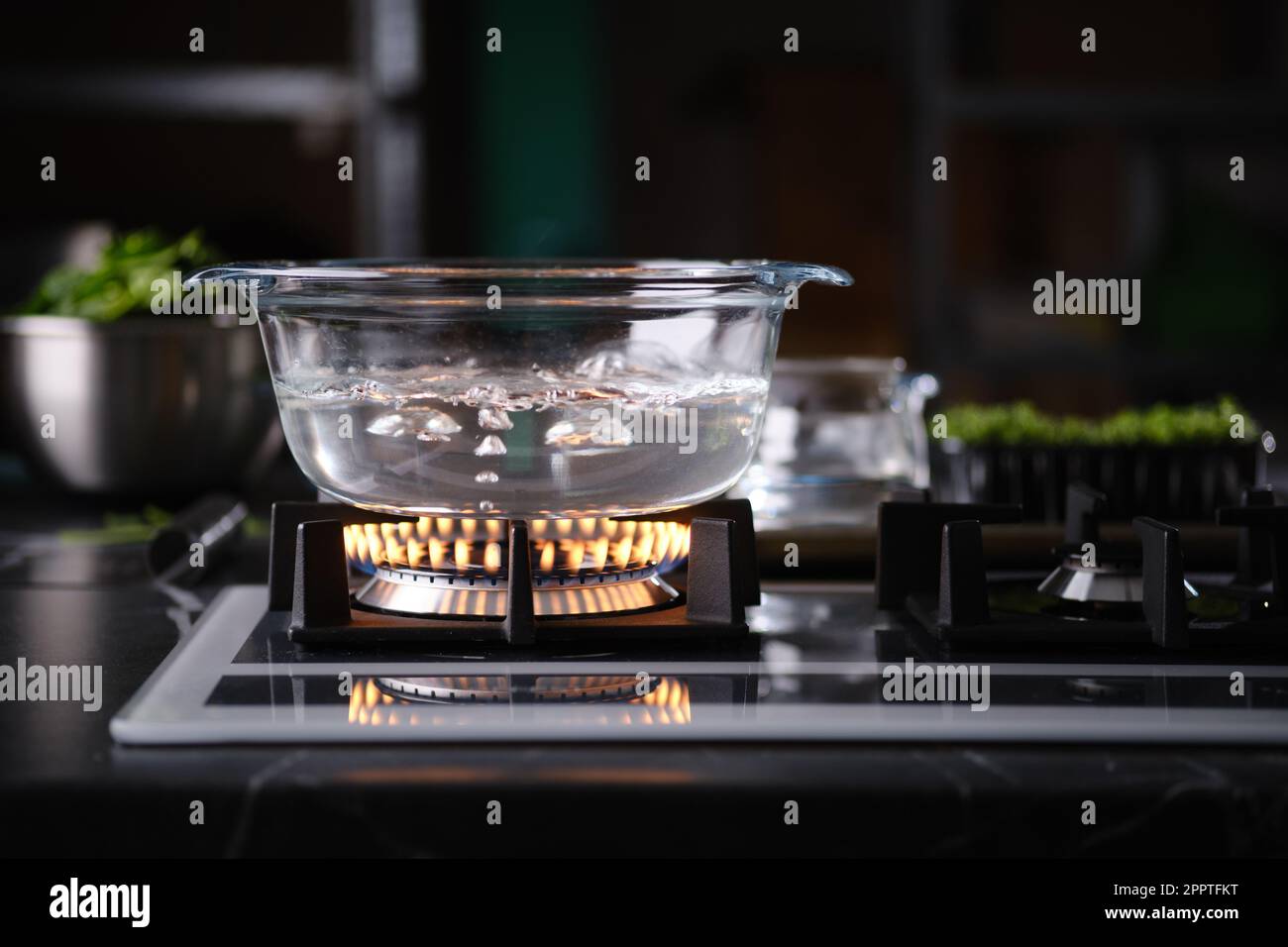 Pentola di vetro sulla fiamma a gas piano di cottura con acqua bollente  Foto stock - Alamy